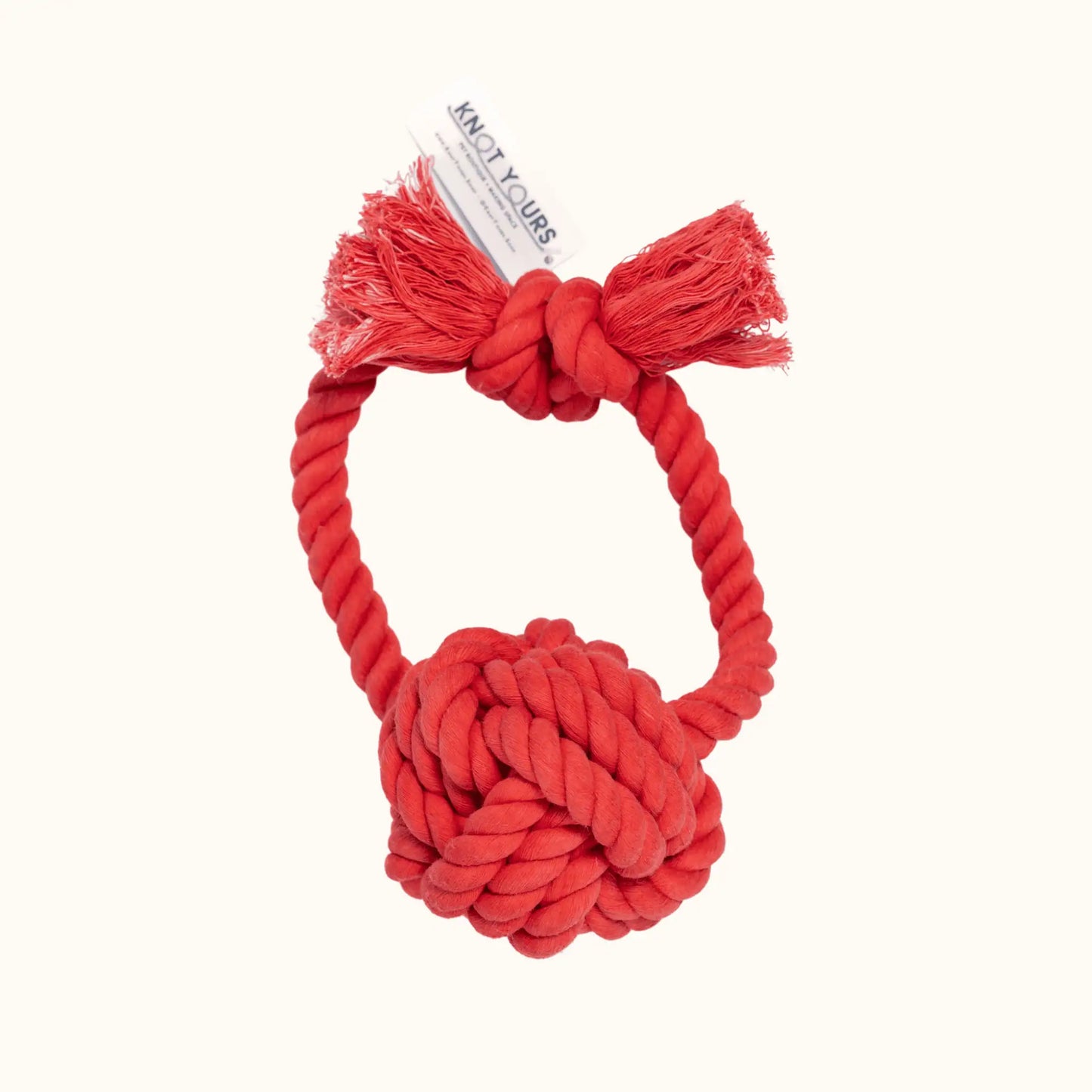 Bright red Giant Monkey Knot dog toy with thick cotton rope, knotted ball, and tassel-like frayed ends, shown upright on a cream background.