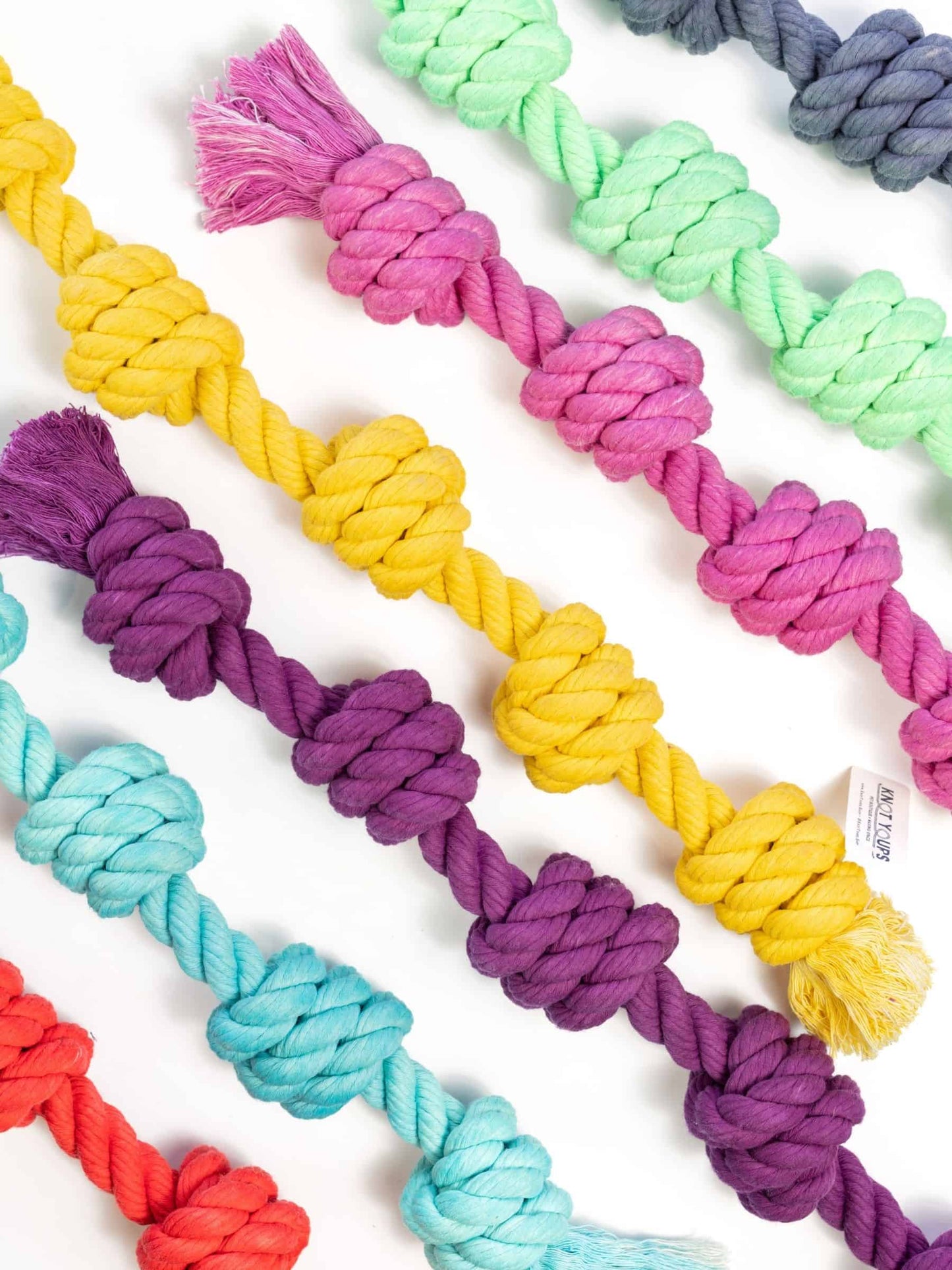 Flatlay of colorful Big Gigantic rope toys with five large knots in various shades, made for large dogs