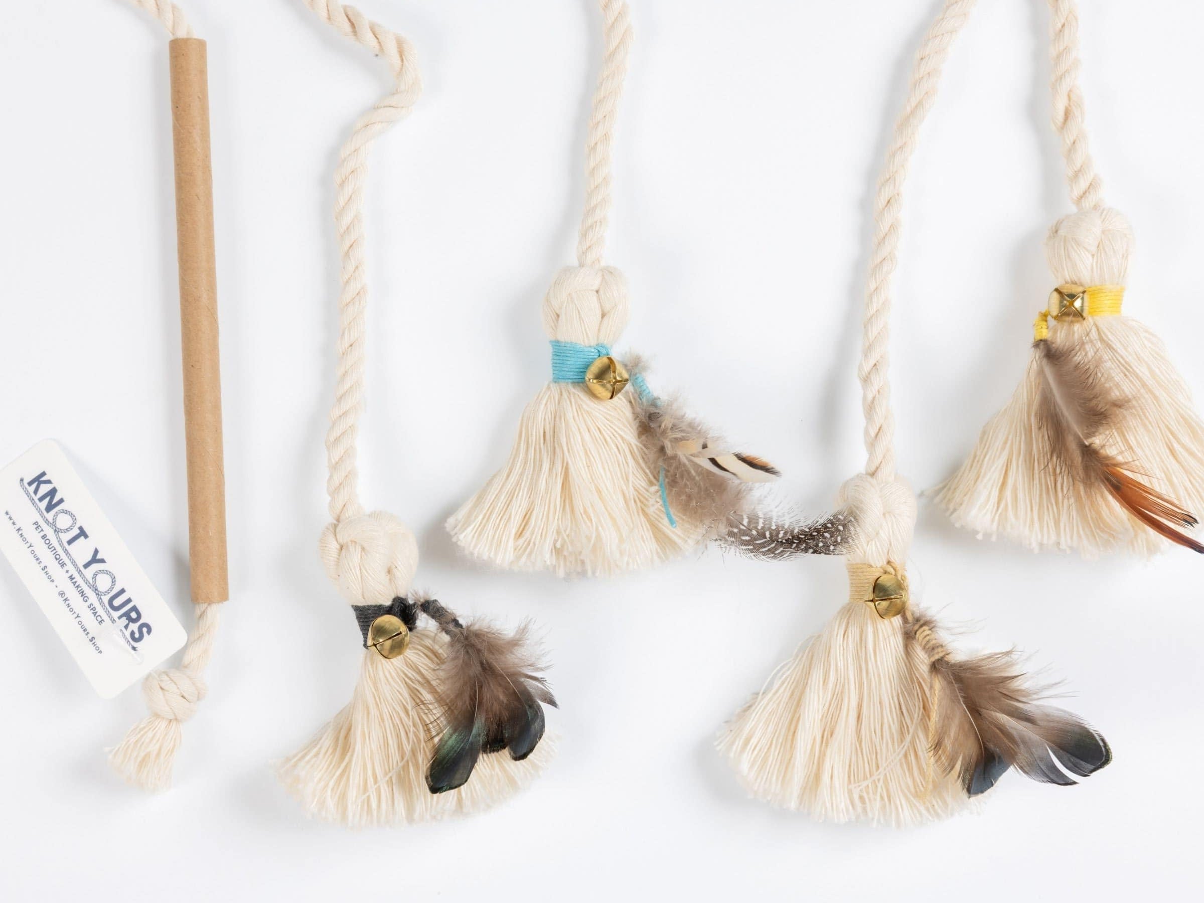 Set of natural cat wand toy attachments with cotton tassels, feathers, and bells in assorted colors for interactive play.