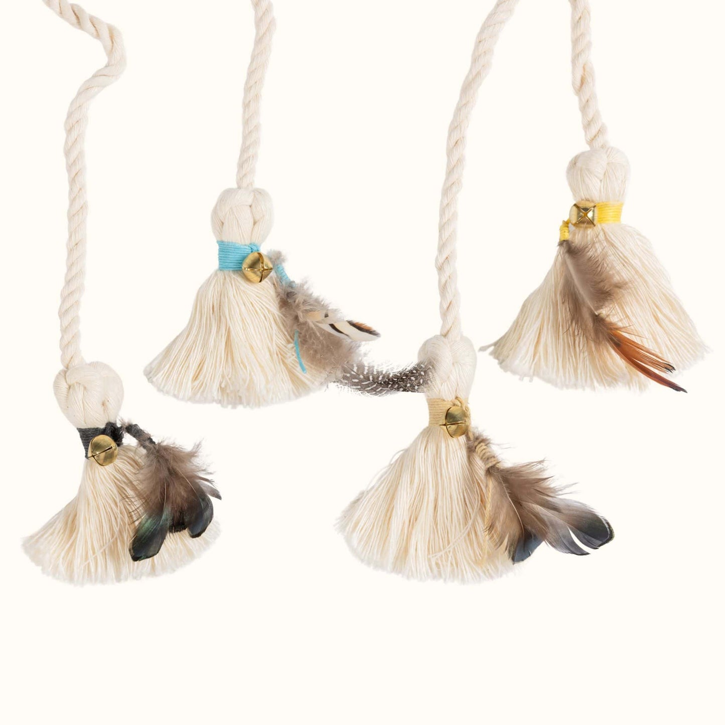 Set of natural cat wand toy attachments with cotton tassels, feathers, and bells in assorted colors for interactive play.