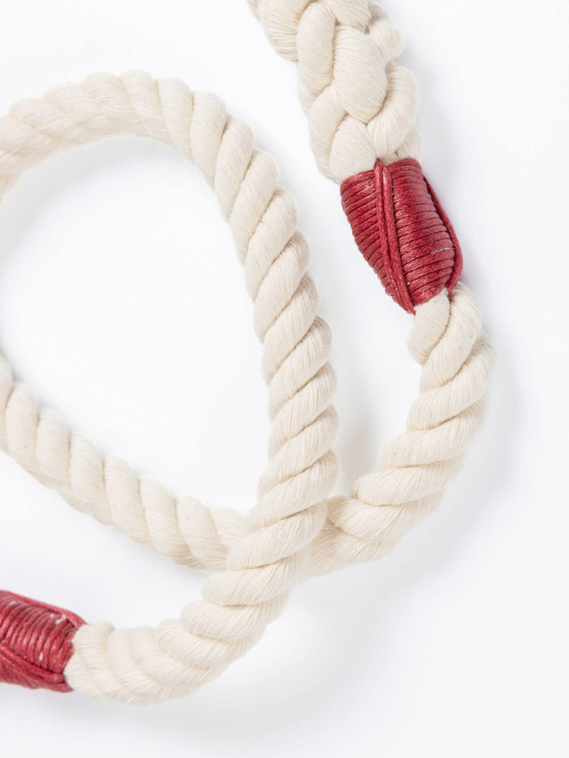 Natural handmade rope leash with red whippings on a white background