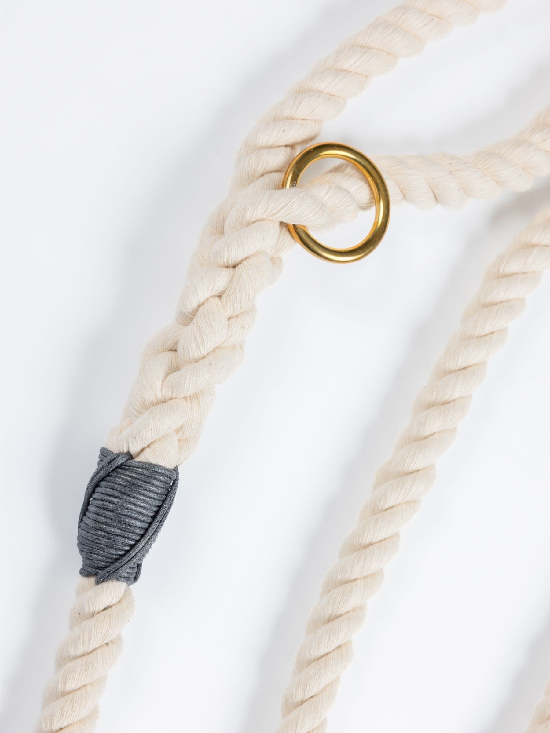 Natural custom made rope dog leash with a gold ring and gray knot on a white background