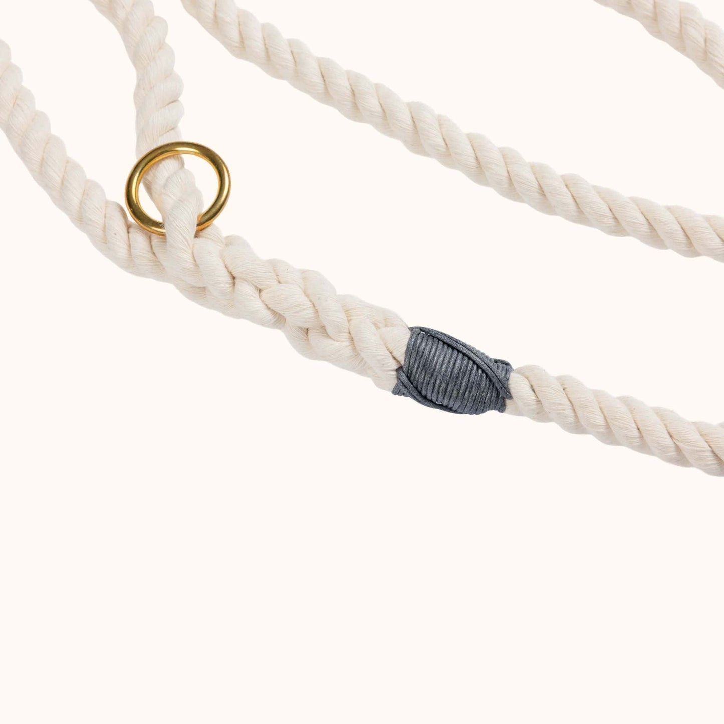Natural custom made rope dog leash with a gold ring and gray knot on a white background