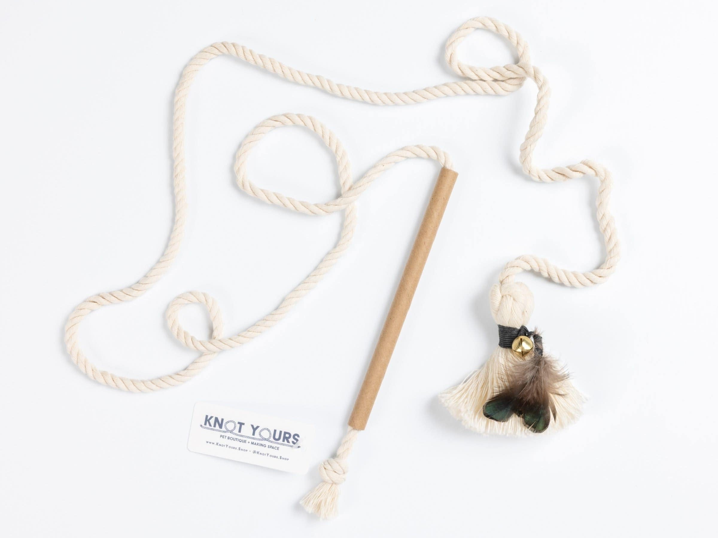 Cat toy with rope and feather on a white background