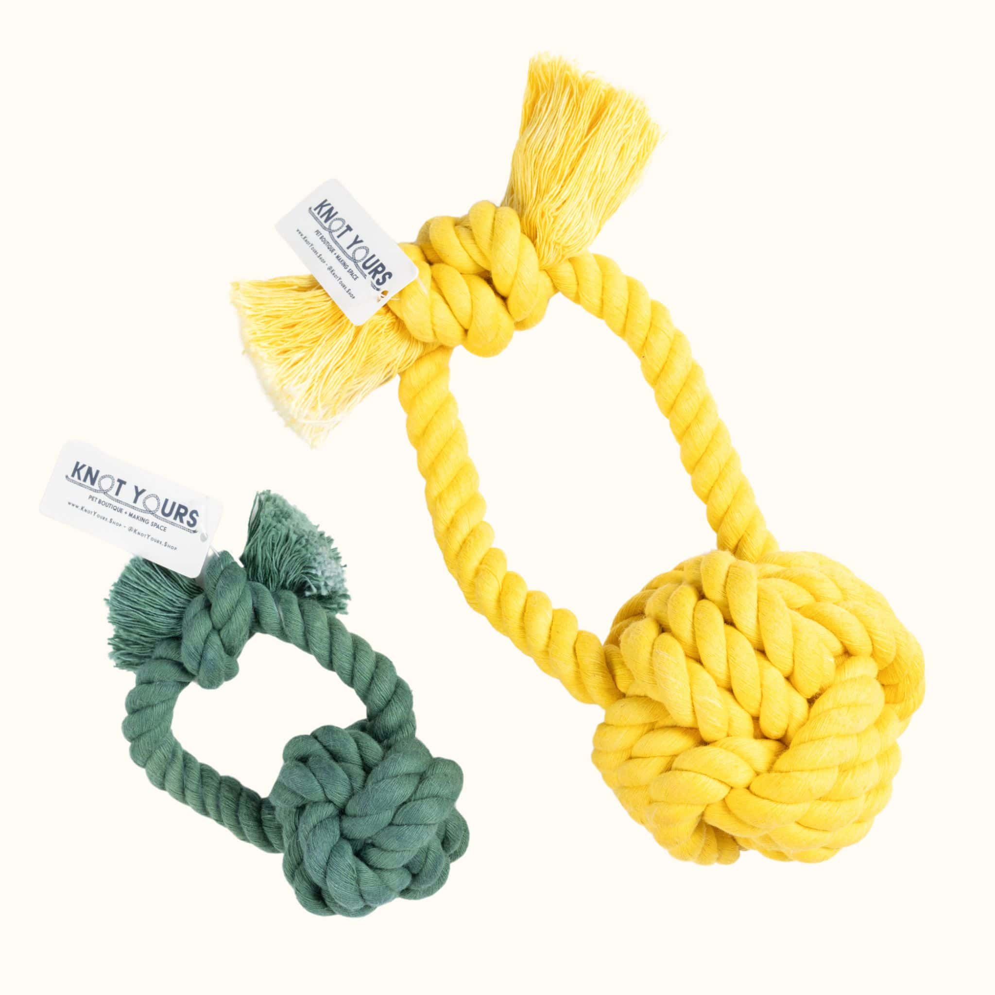 Knot Yours Giant Monkey Knot dog toy in yellow next to a smaller evergreen version, both with thick rope handles and durable knots for tug play.