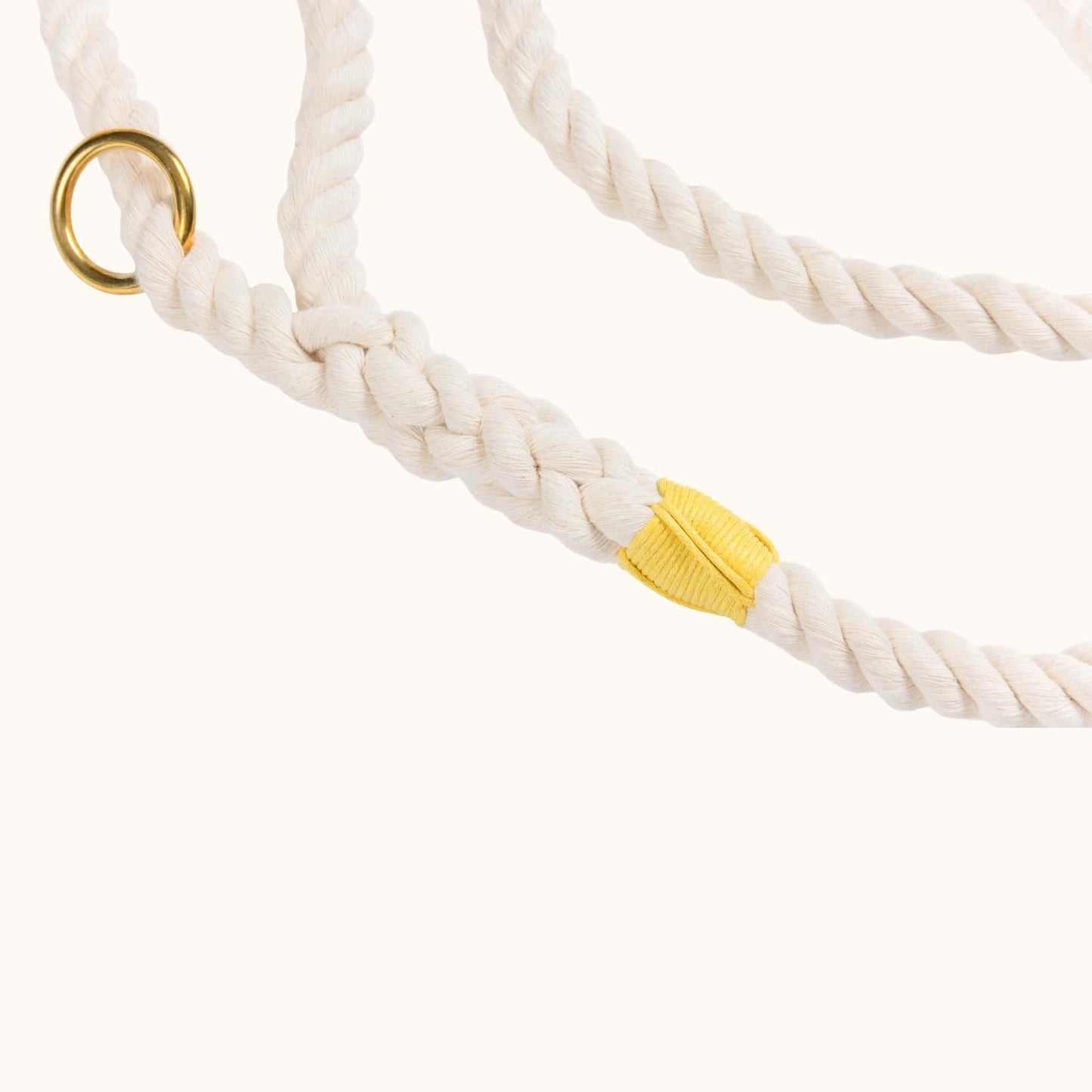 Close-up of a handmade natural cotton dog leash with bright yellow whipping.