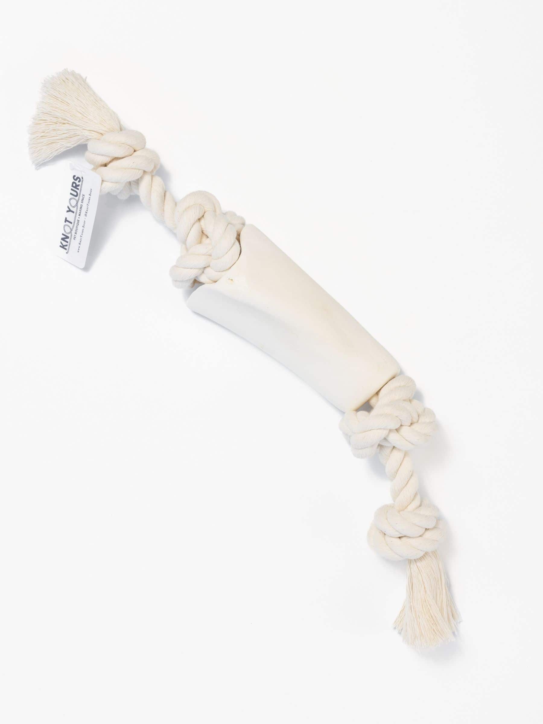 Large dog chew toy with a natural colored rope that goes through a beef bone on a white background