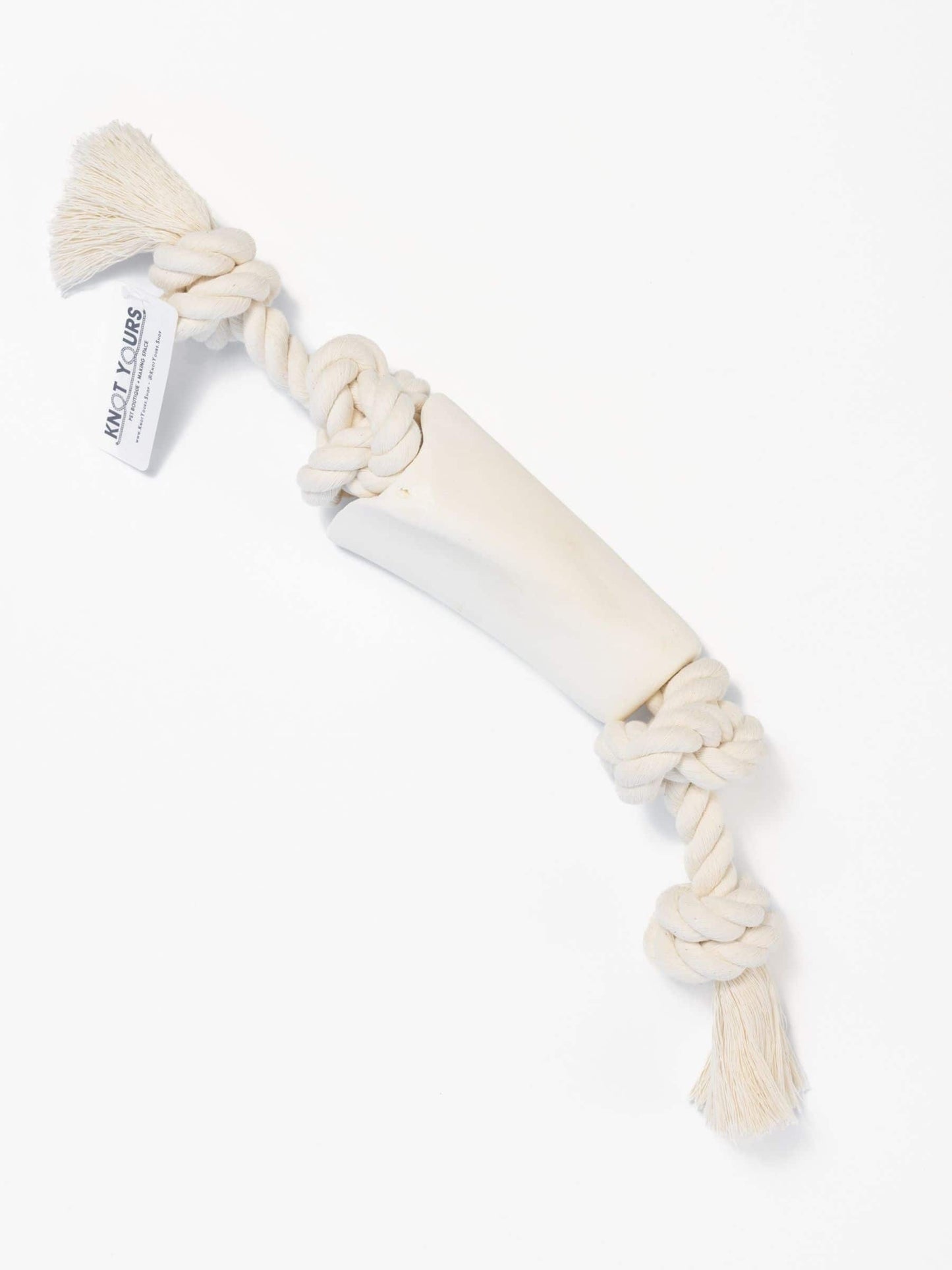 Large dog chew toy with a natural colored rope that goes through a beef bone on a white background