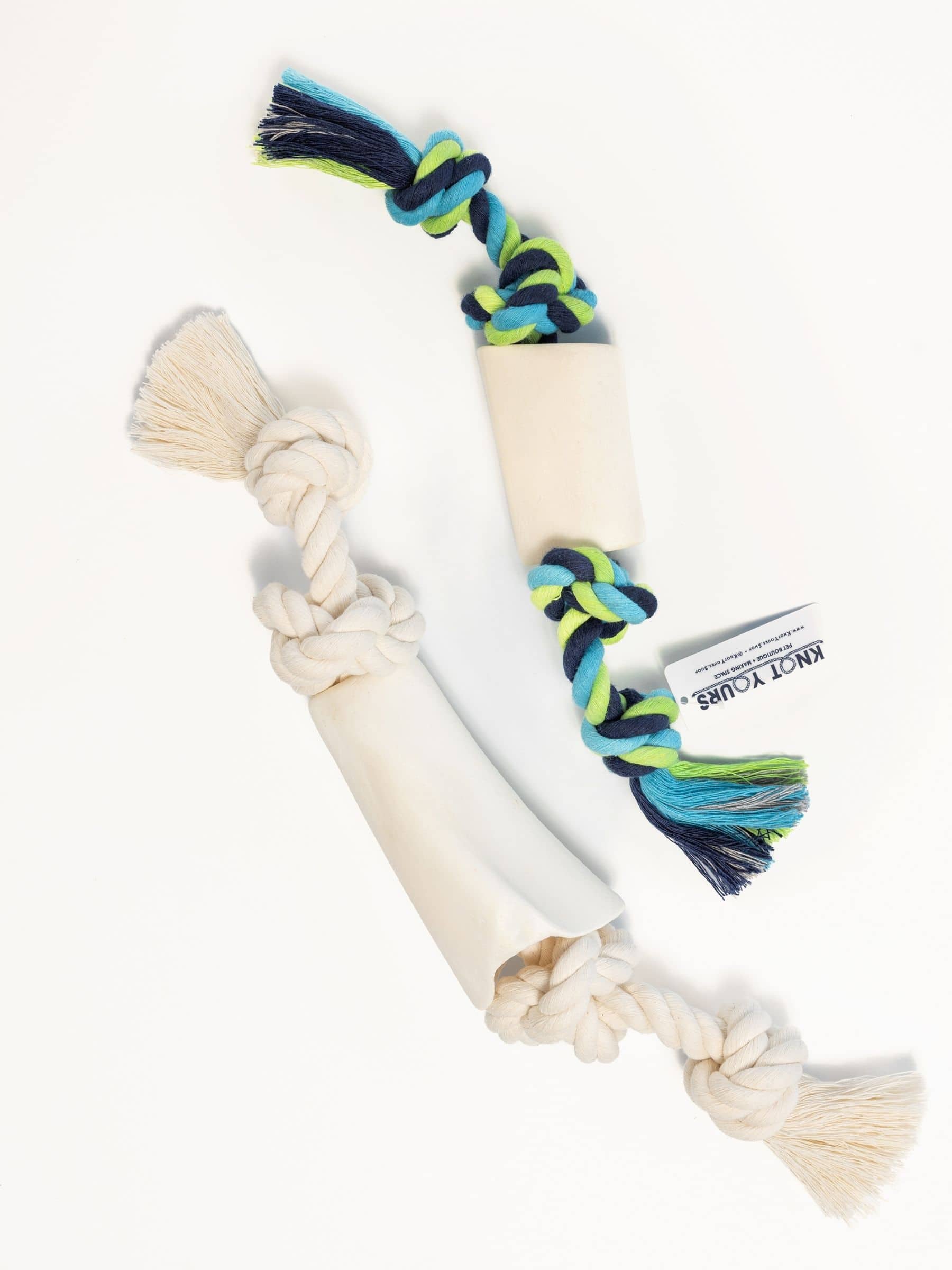 Natural color and multicolored dog chew toy with rope and bone on a white background