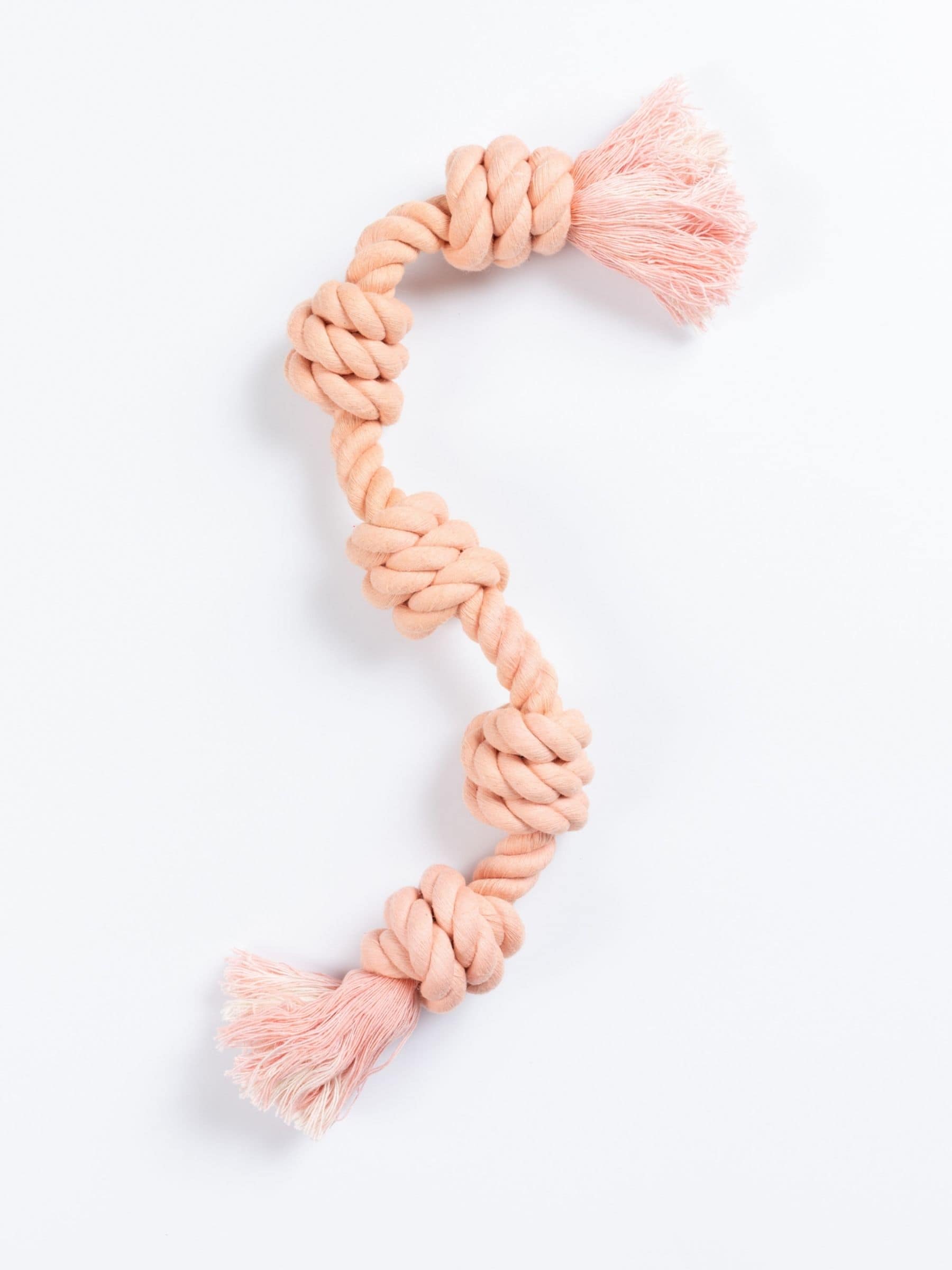 Rose quartz knotted rope toy on a white background