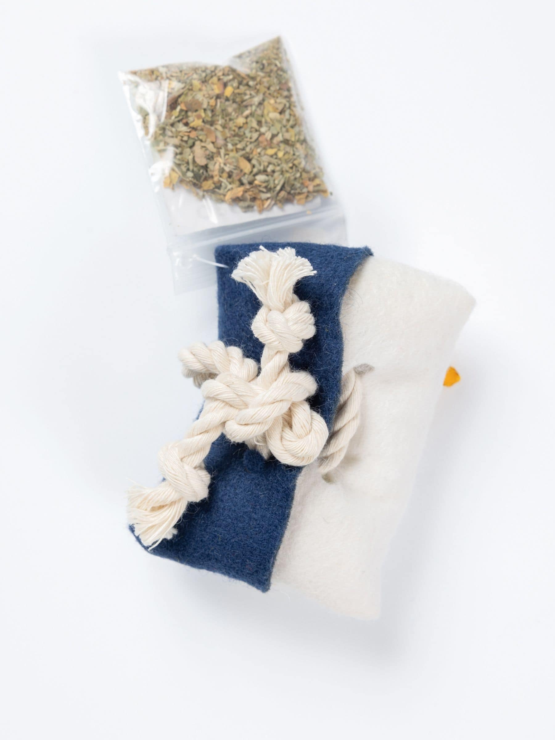 Back view of Tulsa Flag Catnip Pillow with knotted rope closure and bag of organic catnip refill.