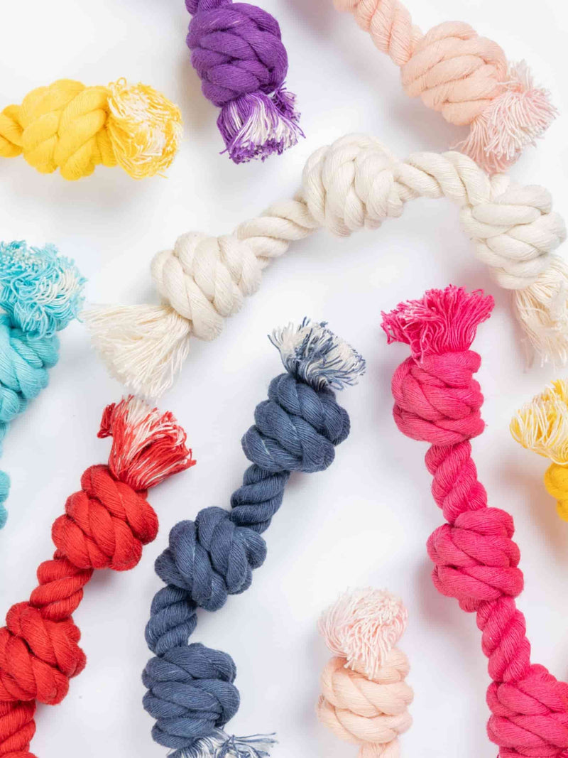 Close-up mix of colorful Baby G chew toys for small dogs, made with knotted cotton