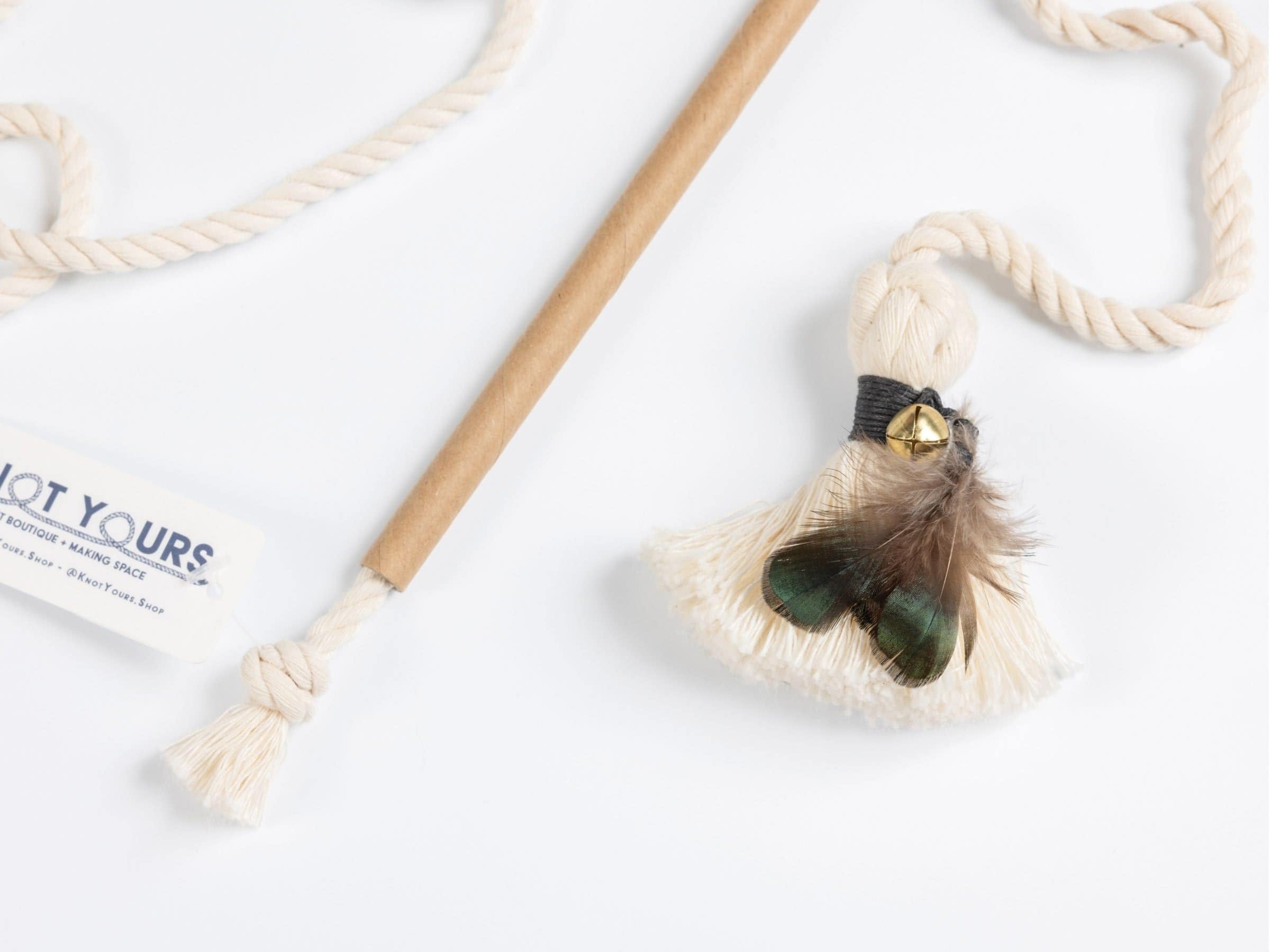 Interactive cat wand toy with a cardboard handle, long cotton rope, and black-banded feather tassel attachment for active play.