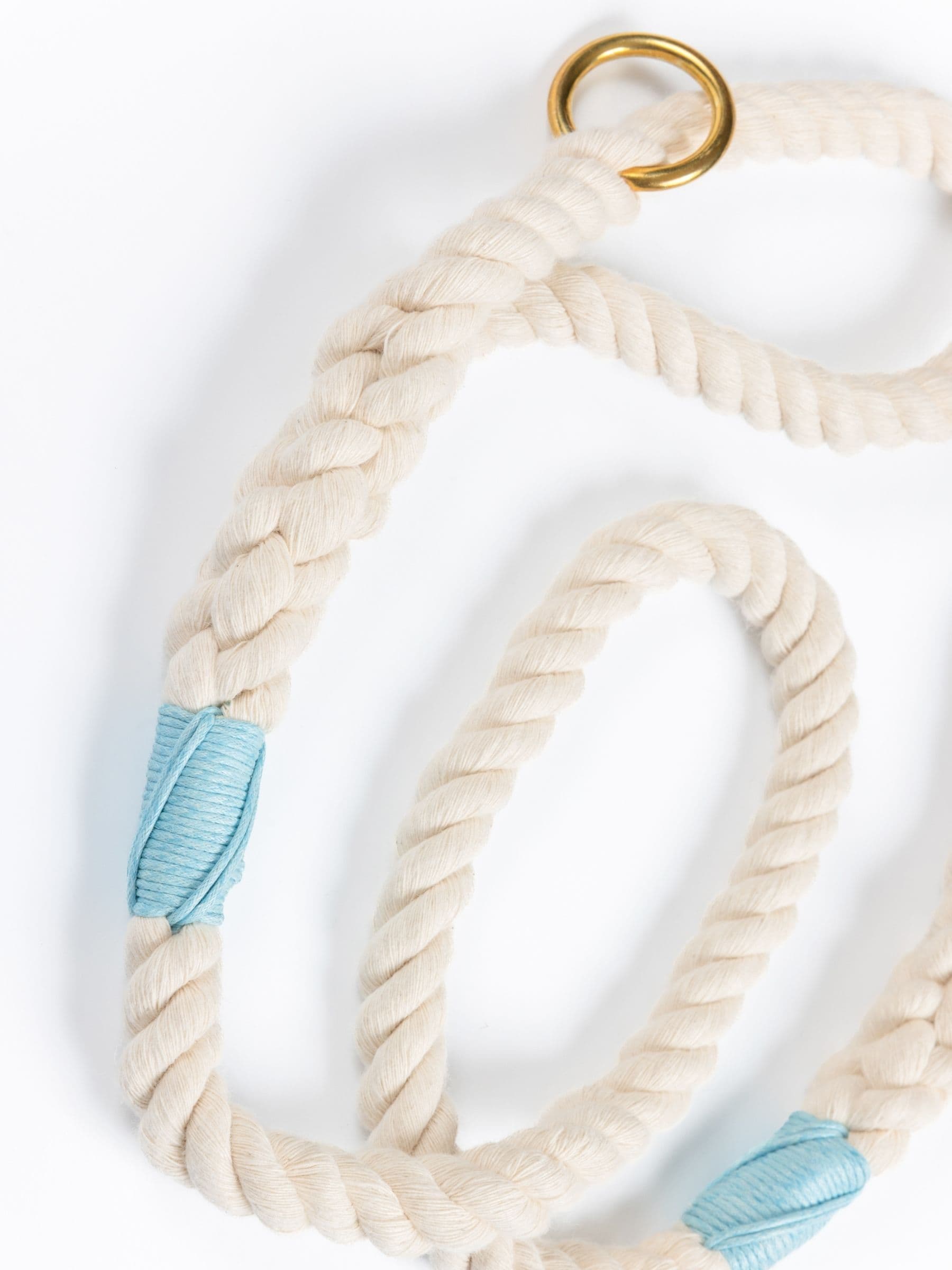 Natural rope lead with blue whipping and a gold clasp on a white background