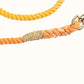 Natural multicolored orange dog leash with a pink and green whip