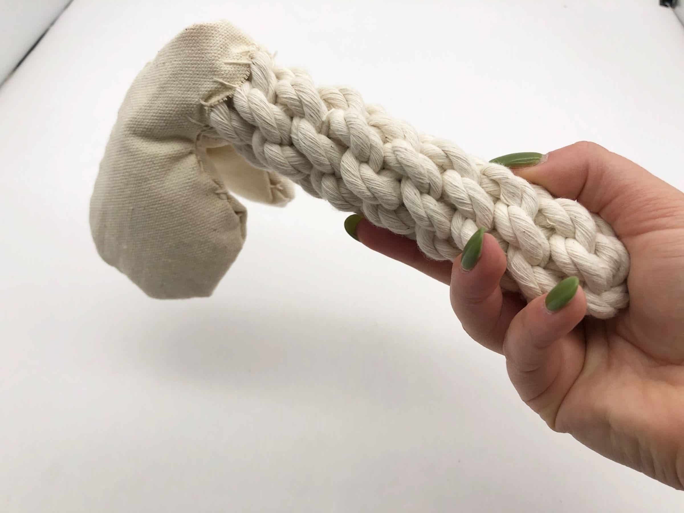 Natural cotton rope dog toy shaped like a penis, with a stitched canvas tip and braided handle for durability and grip.