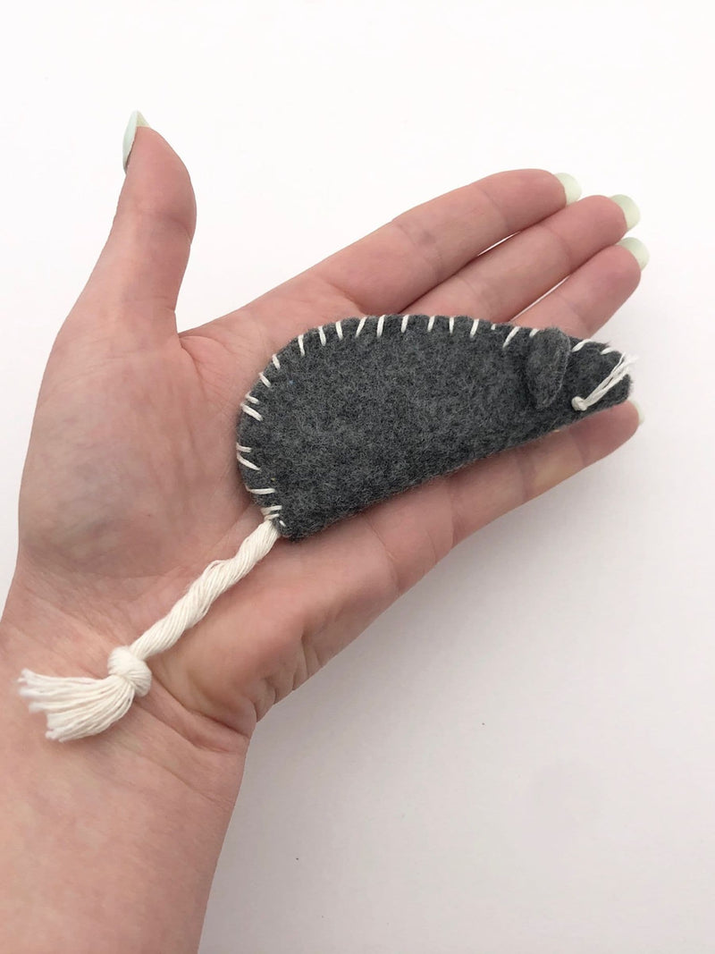 Hand holding grey felt mouse cat toy with stitched edges and rope tail, soft and playful catnip toy for cats.