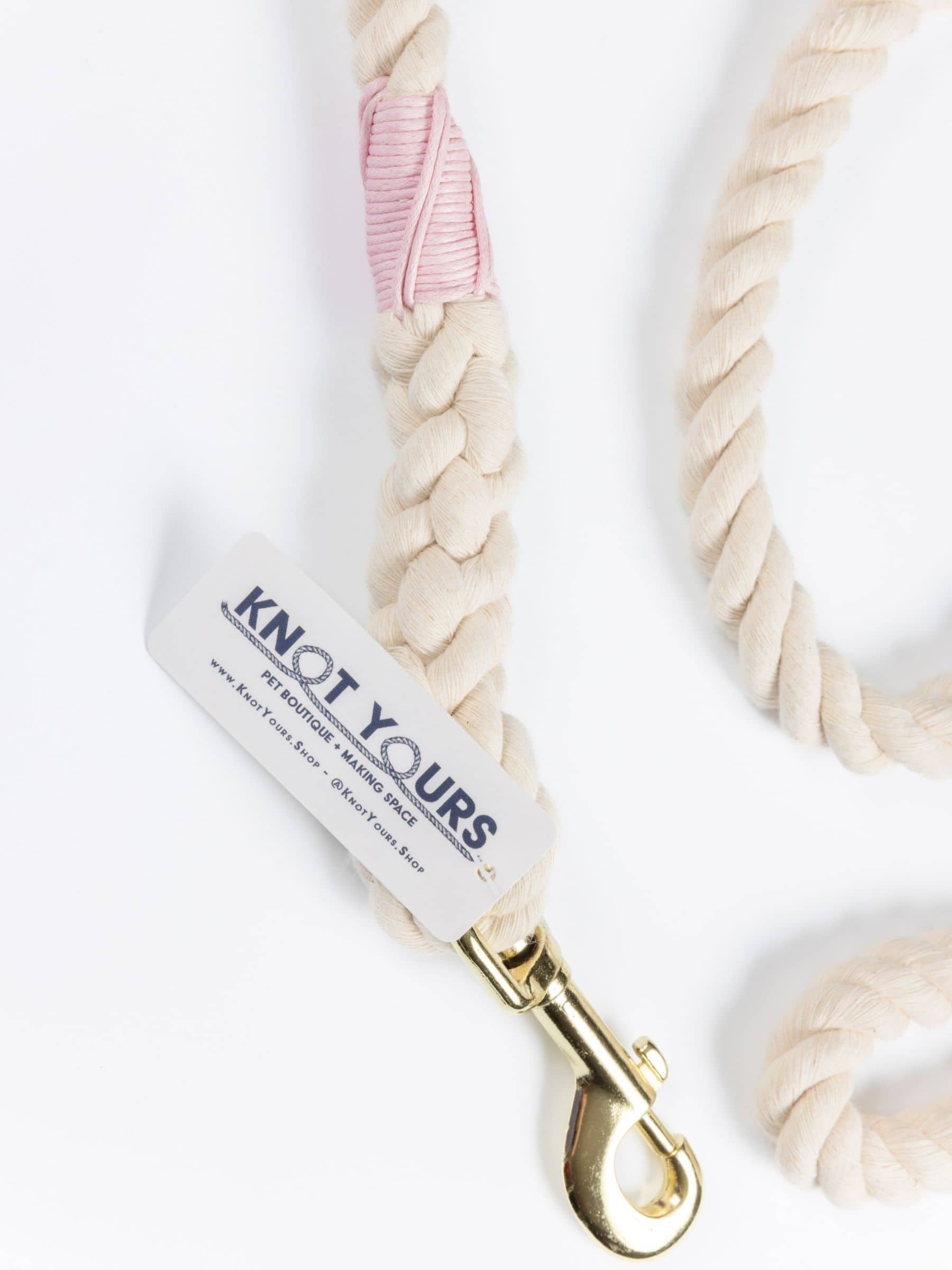 Close-up of a handmade natural cotton dog lead with light pink whipping.