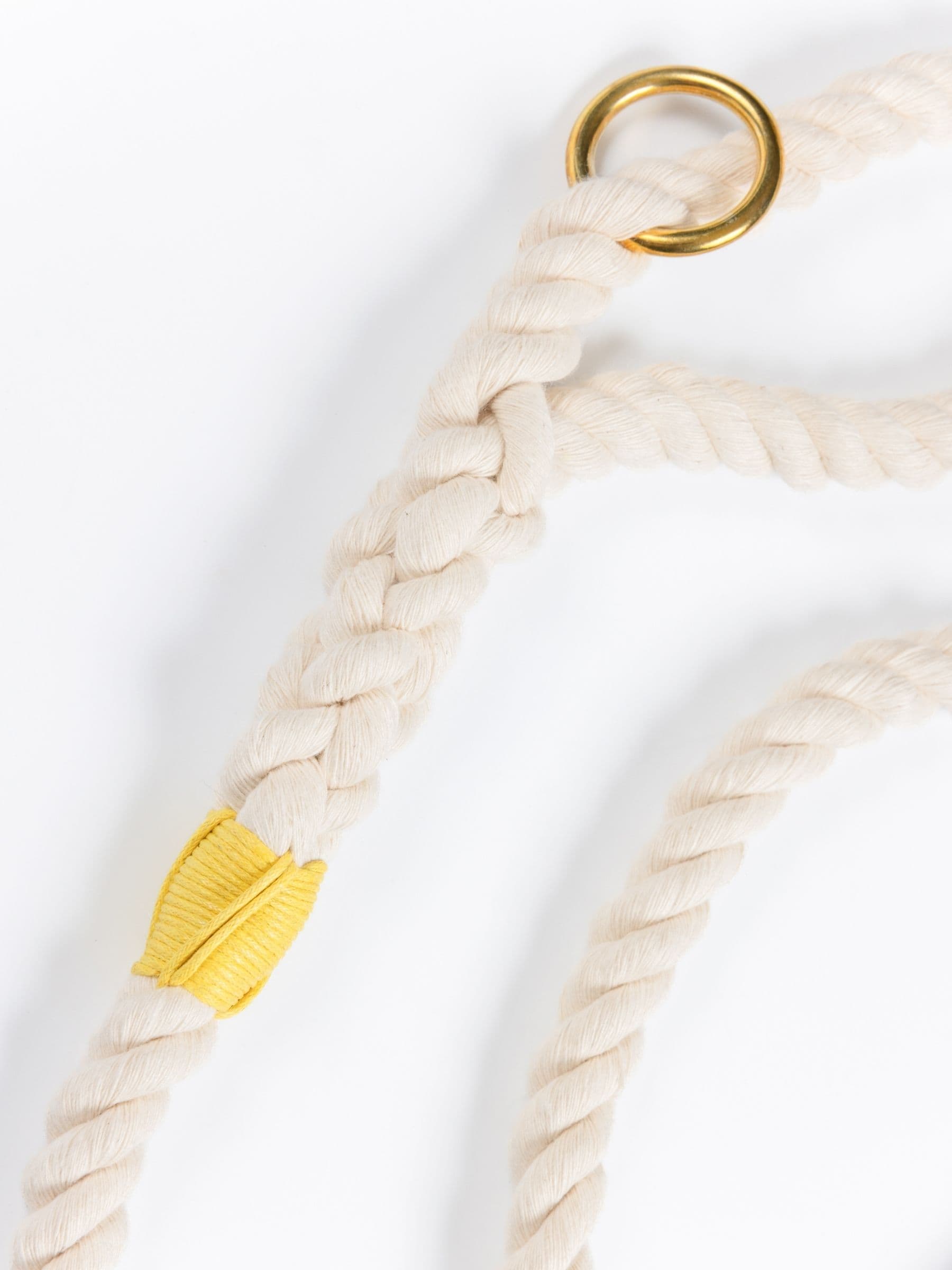 Close-up of a handmade natural cotton dog leash with bright yellow whipping.