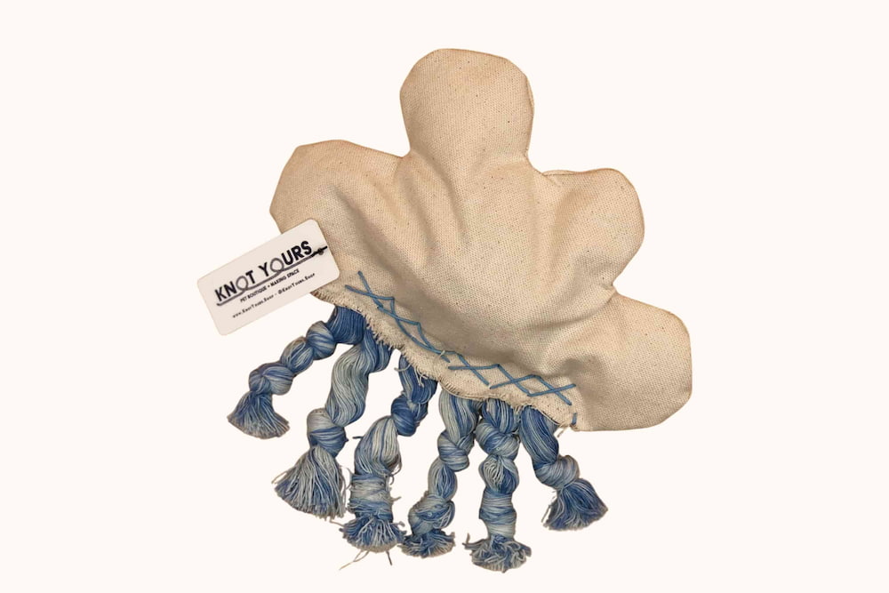 A handmade cloud-shaped dog toy with knotted blue rope tassels and a “Knot Yours” tag.