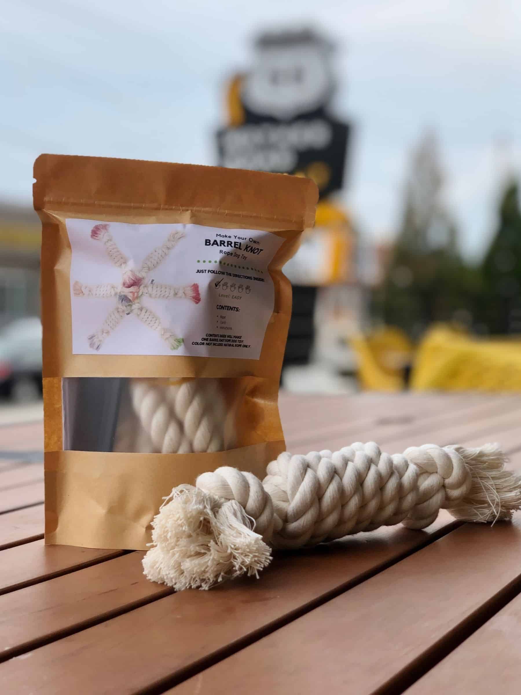 Dog rope toy with packaging on a wooden surface, blurred background