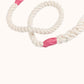 Close-up of a handmade natural cotton dog leash with fuchsia whipping detail.