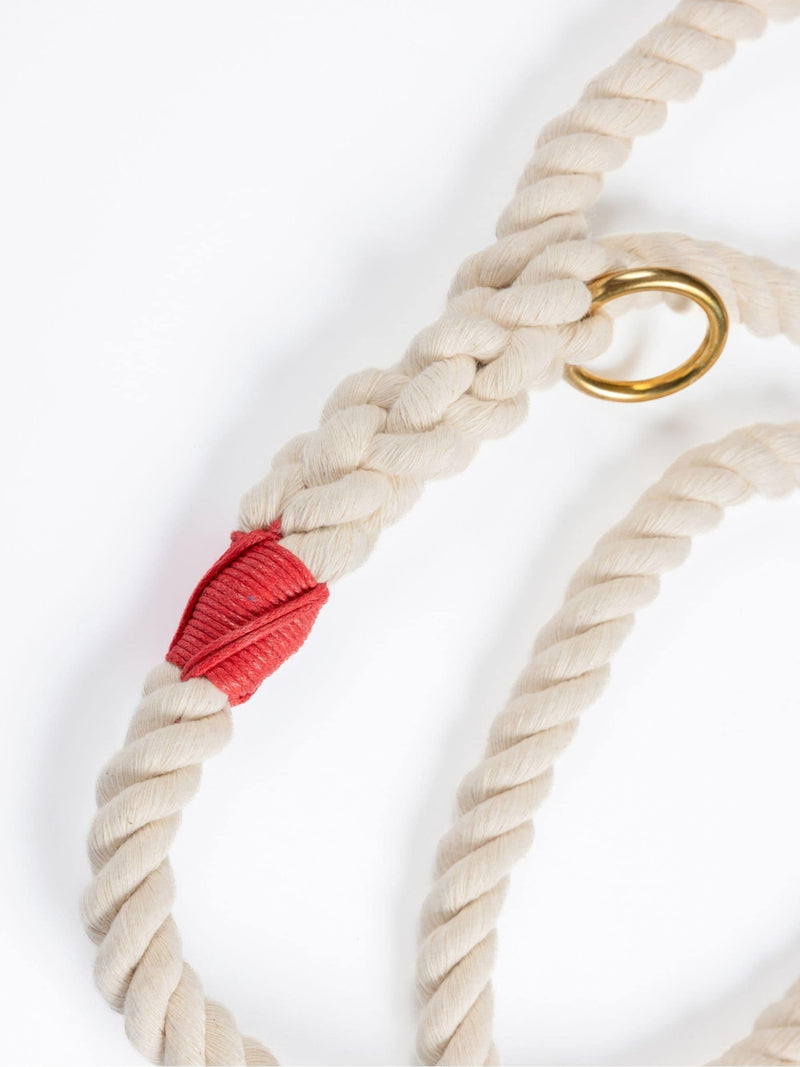 Close-up of a handmade natural cotton dog leash with red whipping and braided rope.