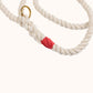 Close-up of a handmade natural cotton dog leash with red whipping and braided rope.