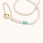 Close-up of custom made natural rope dog leash with teal whipping detail and brass clasp.
