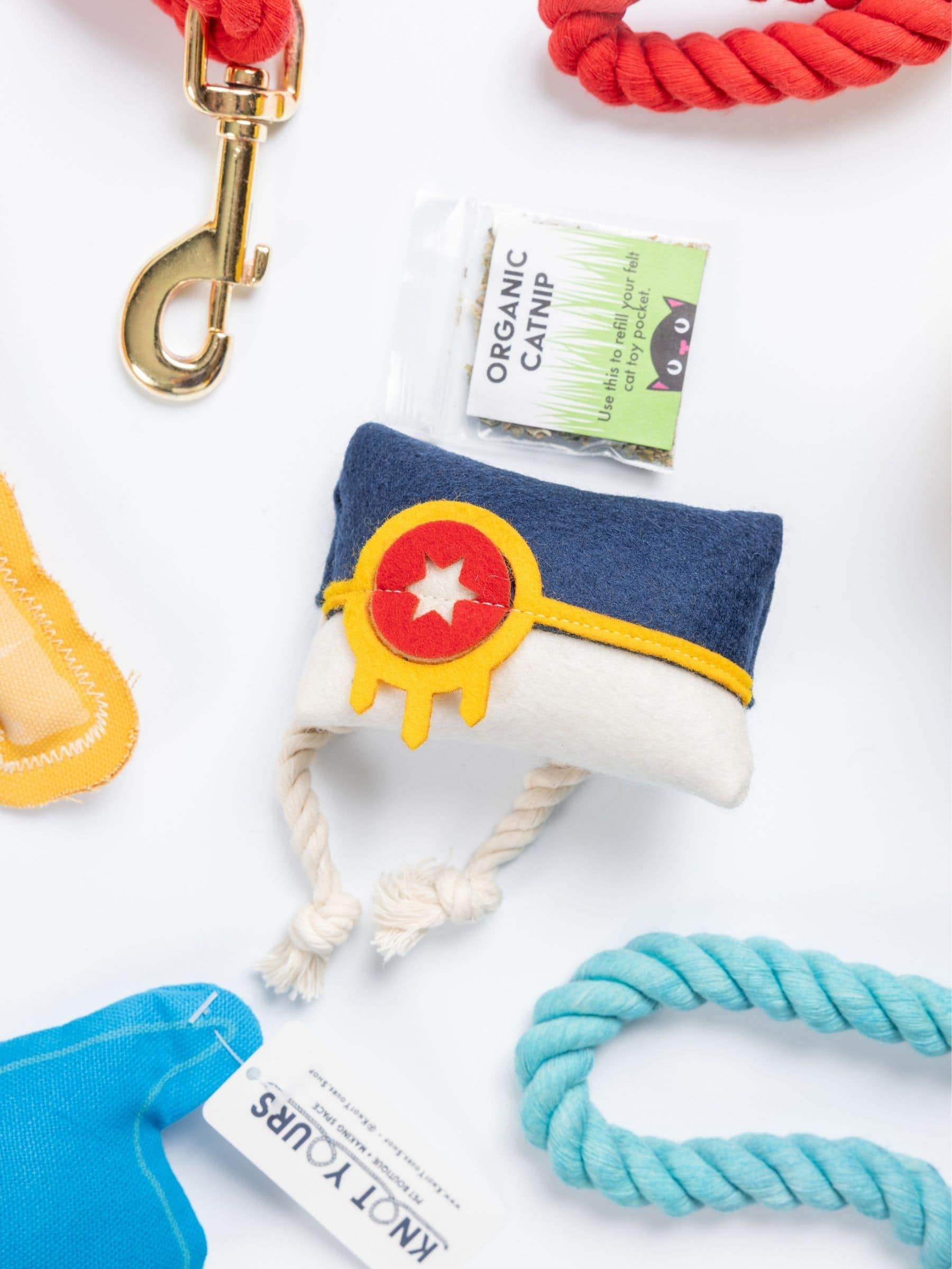 A display of red and blue dog leashes and a catnip toy with the design of the Tulsa flag on a white background.