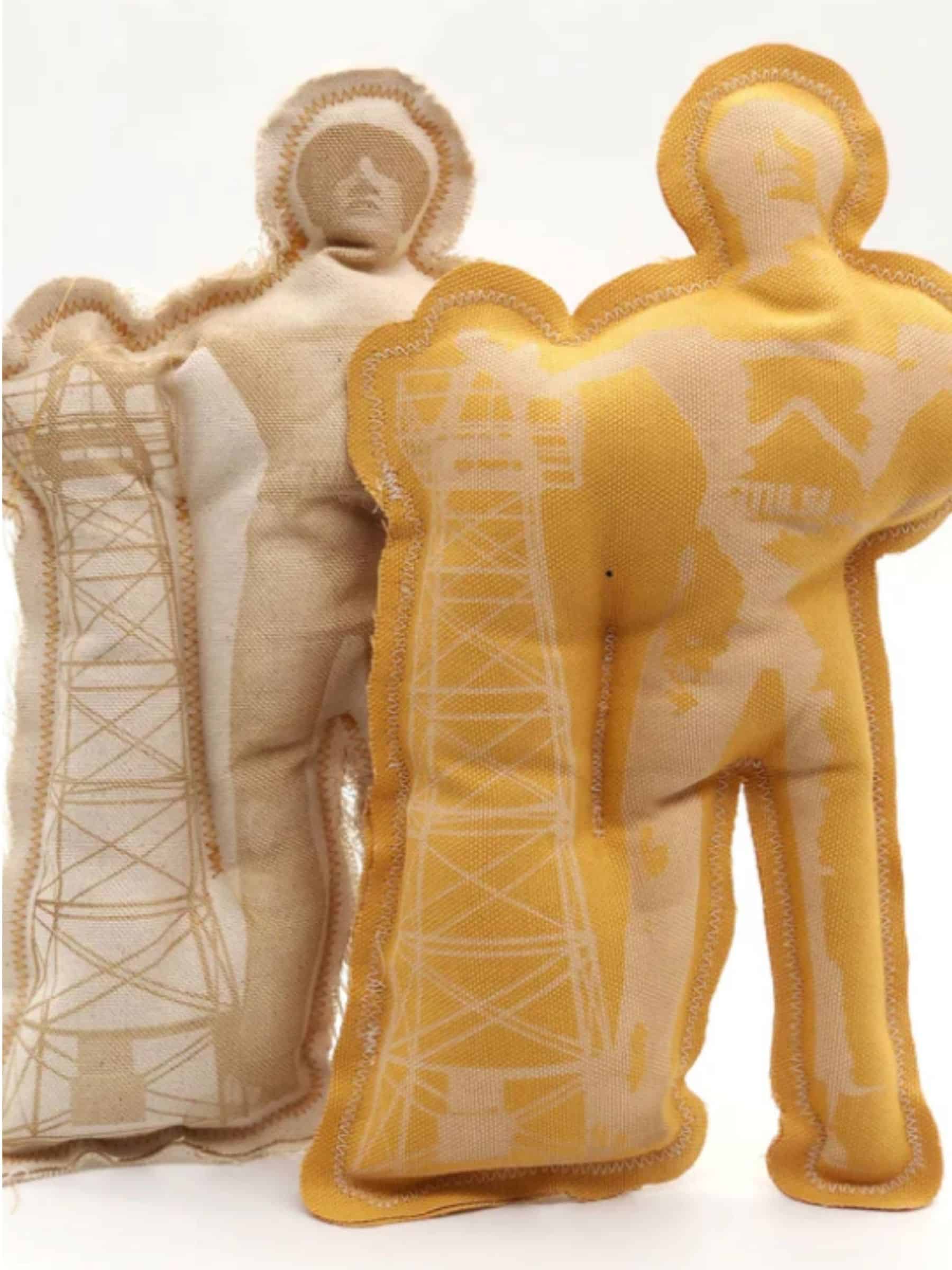 Two Tulsa Driller squeaky dog toys made from durable fabric, shaped like the iconic oil worker statue with tower graphic.